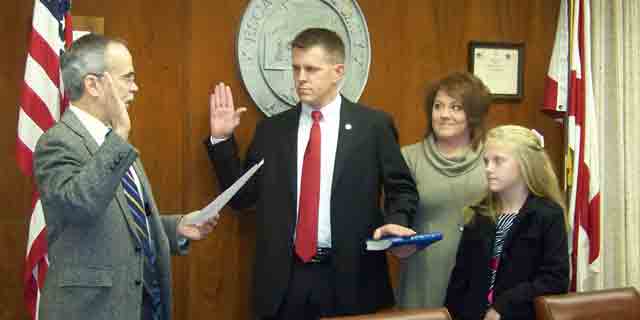 Brandon Smith, center, takes oath as District 4 county commissioner.