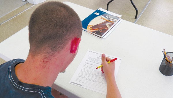 Trent Wright works on the proper way to complete a job application in the YWA class at Hope Place.