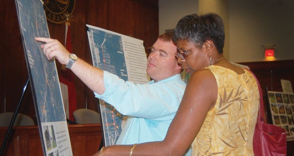 Goodwyn Mills and Cawood planner Brandon Bias shows Brewton resident Kristy Ellis a map of where new entrance signs for Brewton might be located.