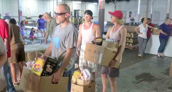 Jason Fuqua, Larry Aucoin and Conner Batson stand ready to help get boxes of food out to needy families Thursday.