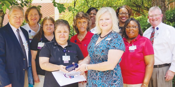 Ruthie Cooper (front left) receives the 2014 Community Volunteer of the Year Award from the American Cancer Society’s Relay for Life presented by Christy Sexton, senior manager. Other D.W. McMillan Hospital Relay team members in the photo include Rick Owens (CFO), Amy Madden, Ellen Crook, Judy Dixon, Alicia Jones, Autherine Davis (HR), Tina Fraser and Chris Griffin (administrator).  