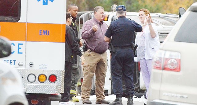 Emergency and law enforcment personnel talk with DWM nurses Lillian Heller (left) and Amanda Morton (right) after the crash.