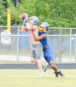 A Neal defensive back and wide receiver battle for the ball.