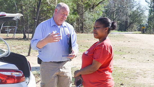 Corey Williams| The Brewton Standard Banton stands outside her home as a claims adjuster  gives her a run through of the damage done to the property.